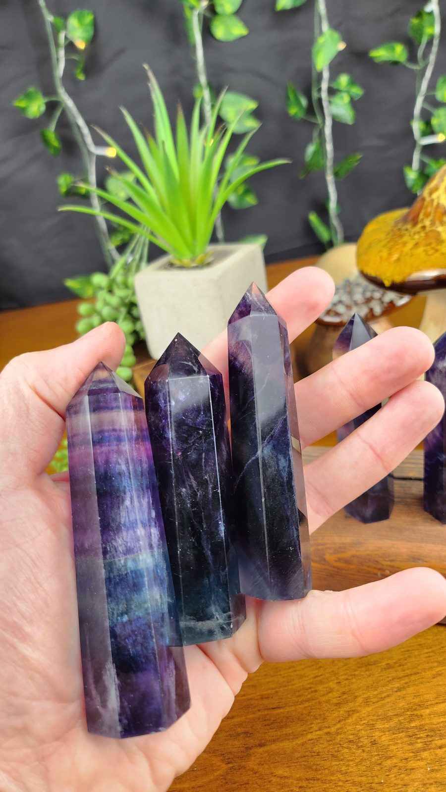 Rainbow Fluorite crystal towers shown in hand for scale.